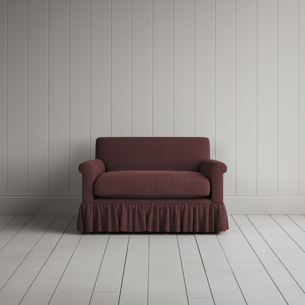 Curtain Call Love Seat playful skirted design in laidback linen damson, front studio view.