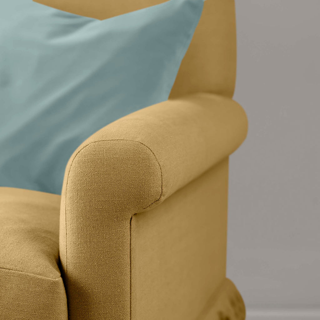 Close-up of premium linen upholstery on a Nicola Harding love seat with a decorative accent cushion.
