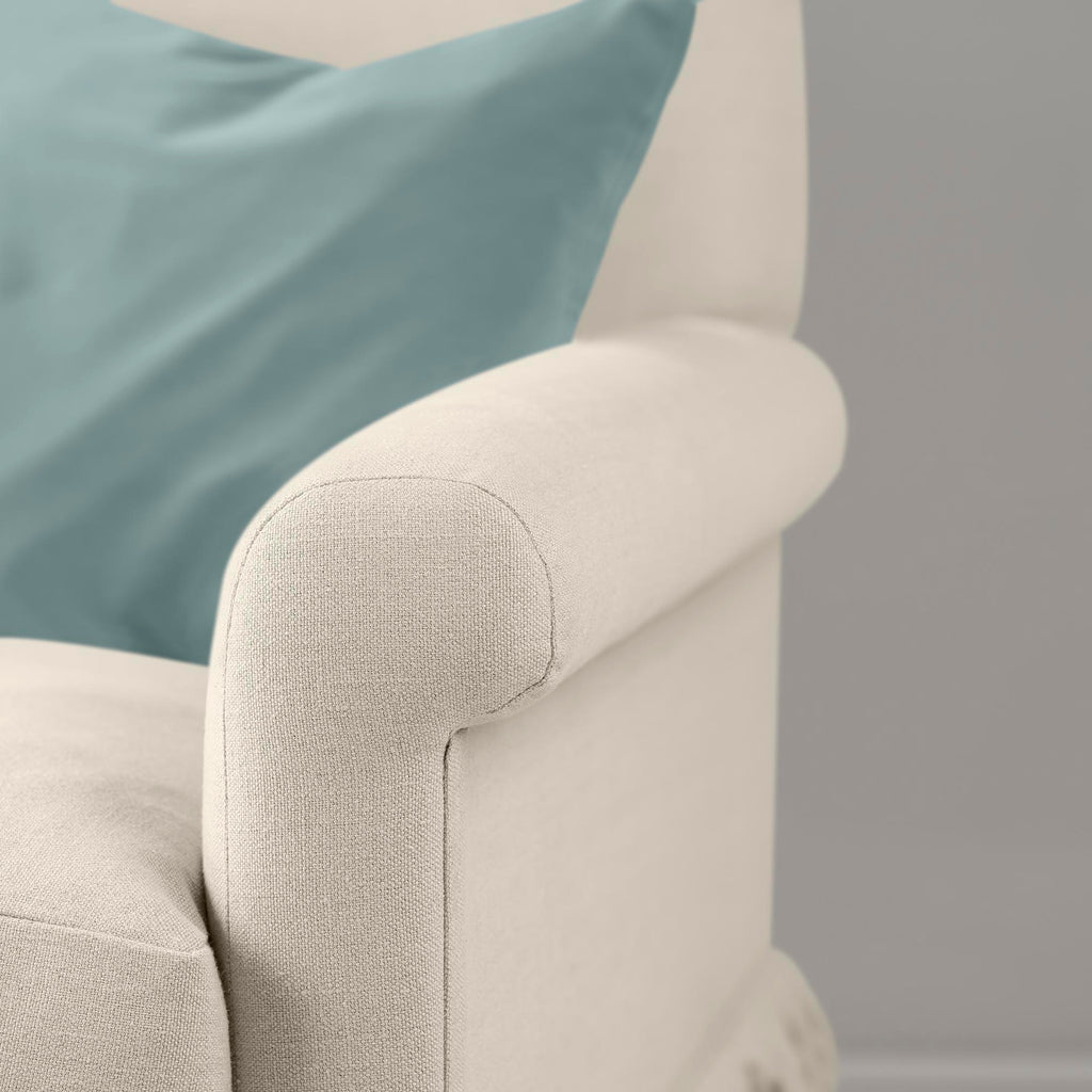  Detail of the armrest on the Dove Curtain Call sofa by NiX styled with a contrasting cushion. 