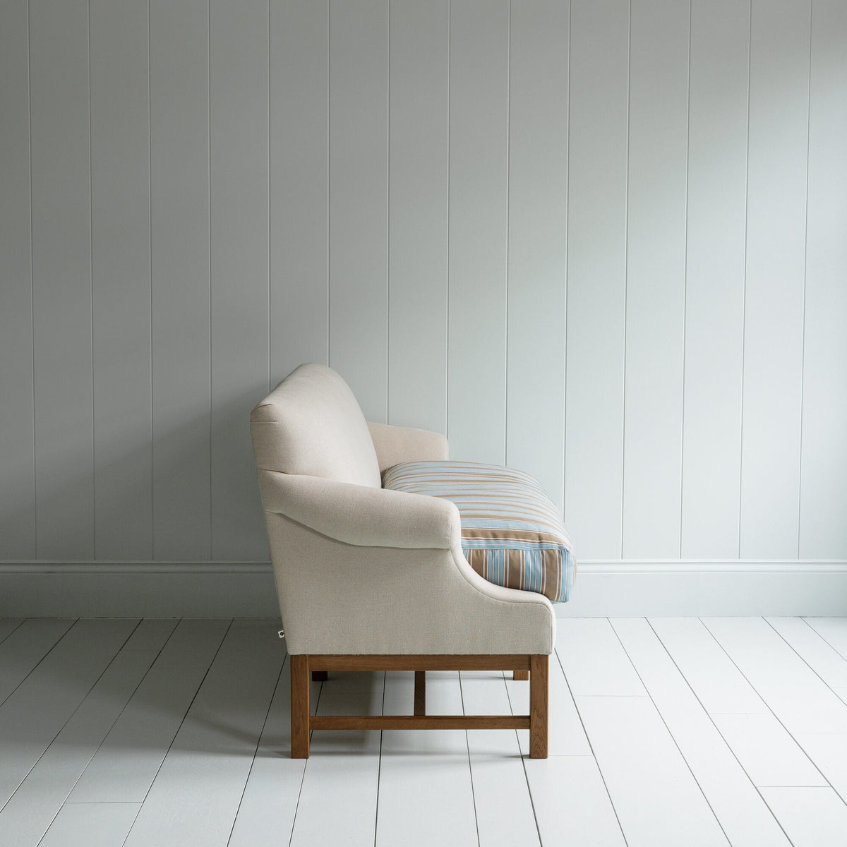 Side View of Front Row 3 Seater Upholstered Bench in Laidback Linen Dove Frame and Regatta Cotton Blue Seat -  By Nicola Harding & Co.