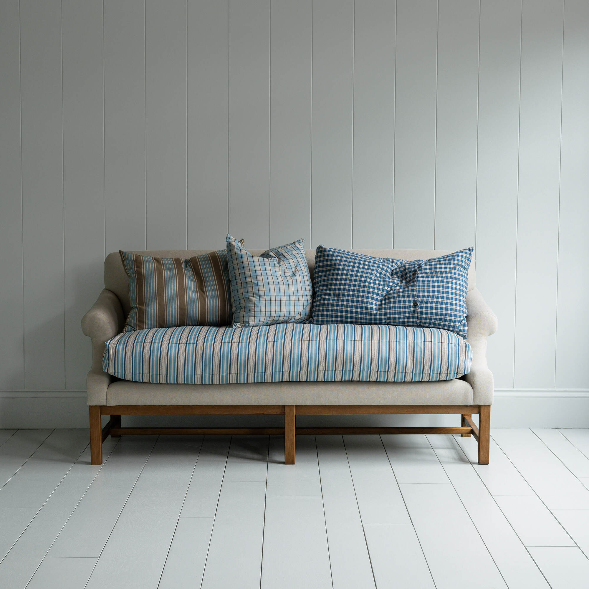  White couch on wooden floor in minimalist living room. 