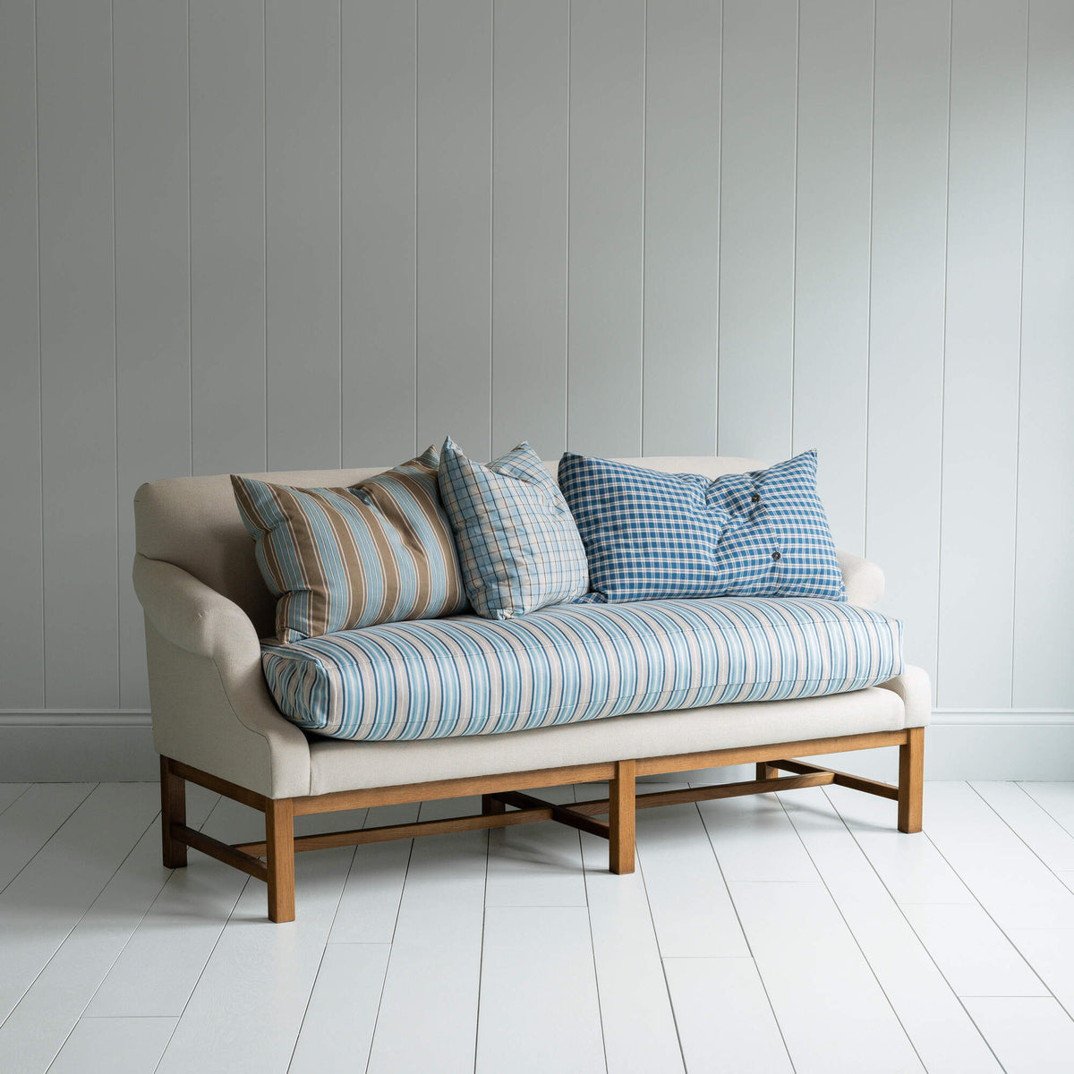 White couch on wooden floor in minimalist living room.