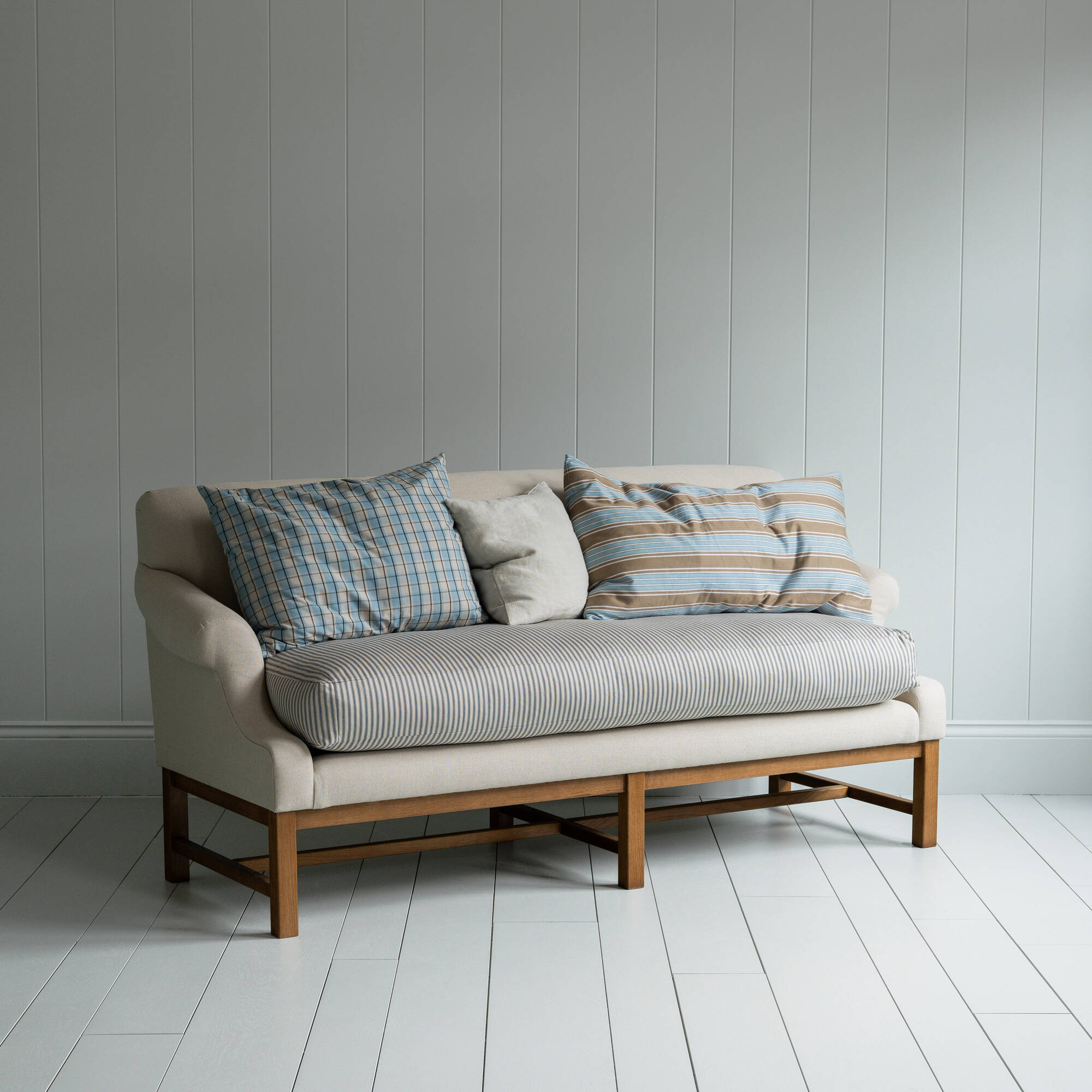  White couch on wooden floor in minimalist living room. 