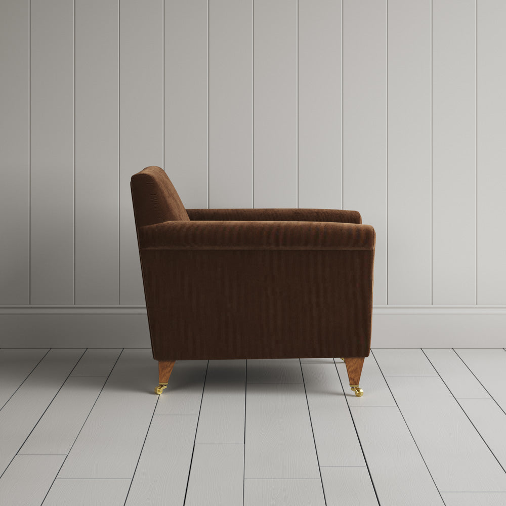  Side profile of the Tobacco corduroy Idler armchair, a versatile occasional chair for a London home. 