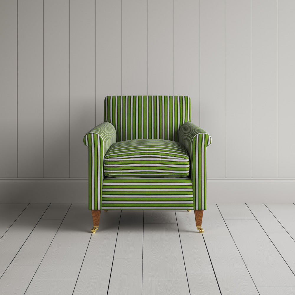  A green and white striped couch against a wall. 