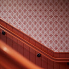 Rhombus wallpaper in Rhubarb and Pink on the wall of the stairs, adding a vibrant design element in our Beaverbrook Village Project 