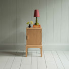 Bits and Bobs Bedside Table, Natural Oak, Right Hand Side Decorated with table lamp and a small flower bottle - Nicola Harding