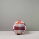 Side View of Bask Bolster Cushion in Checkmate Cotton, Berry - Nicola Harding