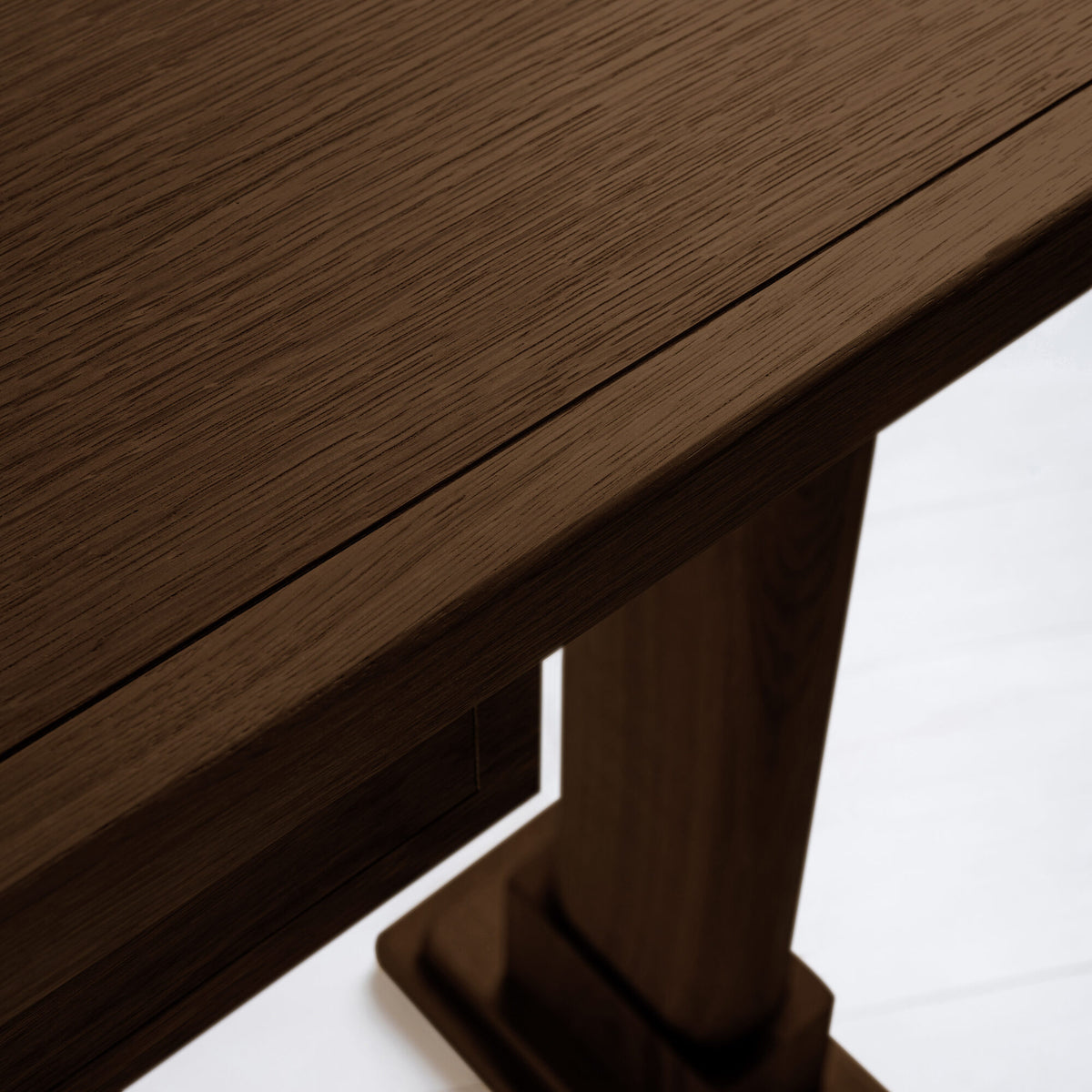 Shelf edge design of a smoky stained oak console table, highlighting the smooth finish and craftsmanship.
