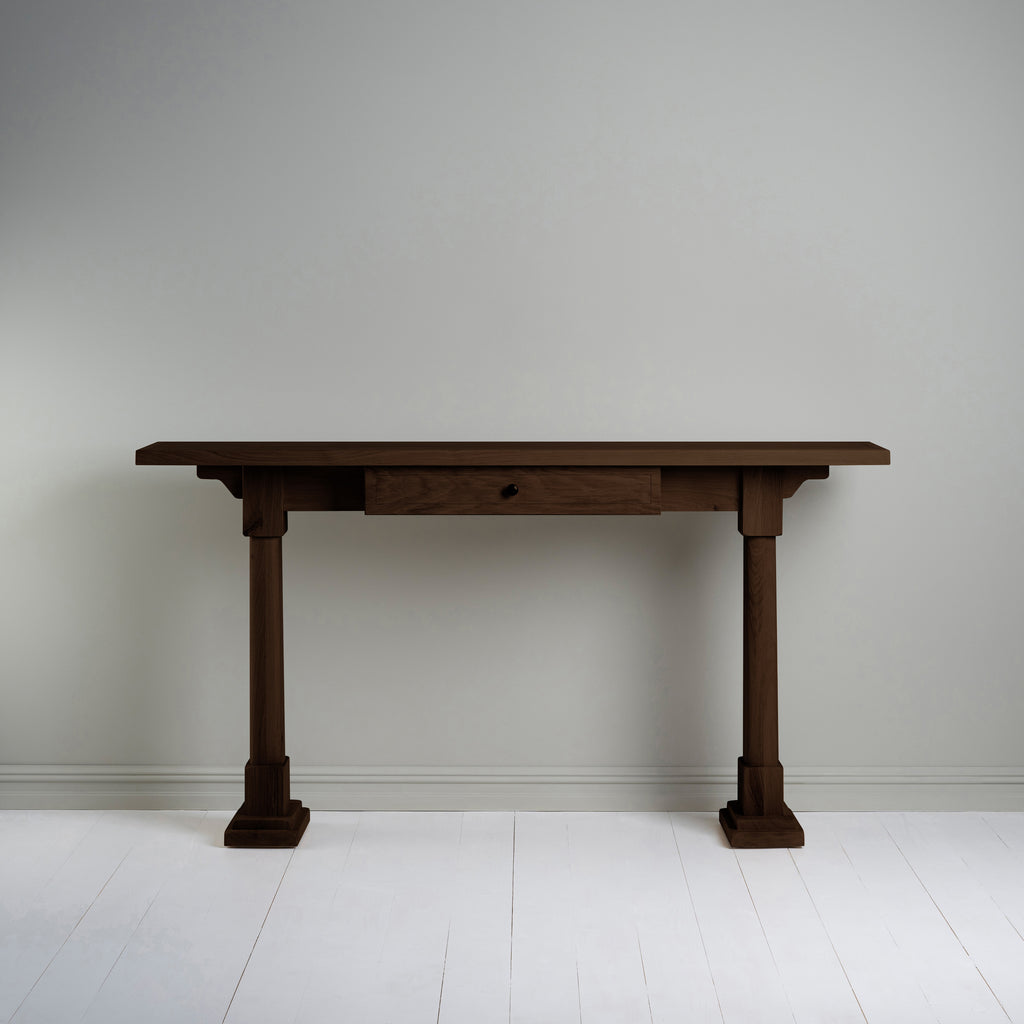  Console Table with a drawer in smoky stained oak, placed against the wall. 