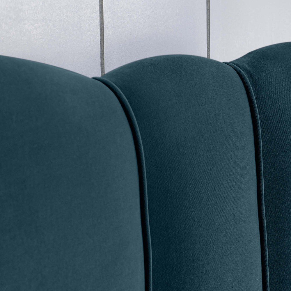 Close-up of the upholstery design on the bed in Intelligent Velvet Aegean fabric, showcasing the sewing details.