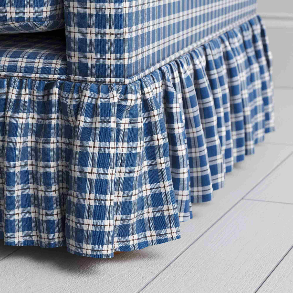 Detailed view of the gathered ruffle skirt and lower base on the Curtain Call sofa by NiX.