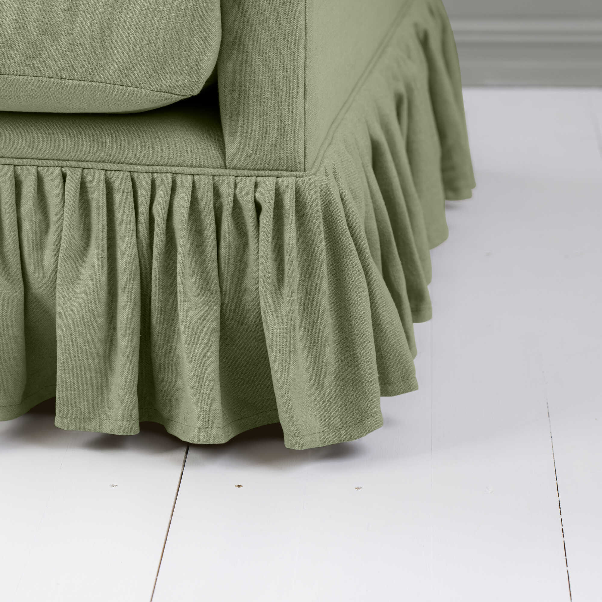 Detailed view of the gathered ruffle skirt and lower base on the Curtain Call sofa by NiX. 