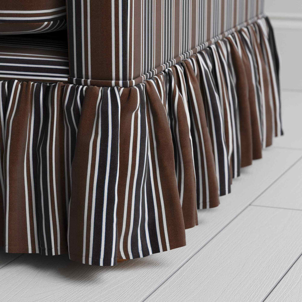  Detailed view of the gathered ruffle skirt and lower base on the Curtain Call sofa by NiX. 