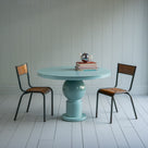 Raconteur Dining Table in Glacier Blue With Books on it
