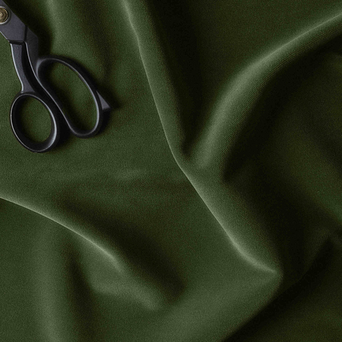 A pair of scissors for cutting green fabric.
