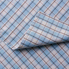 Detailed view of folded Square Deal cotton material in blue brown