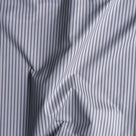 Close-up of folded ticking stripe cotton fabric by Nicola Harding.