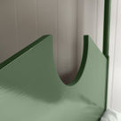 A green metal bed with a white pillow, providing comfort and style to any bedroom decor.