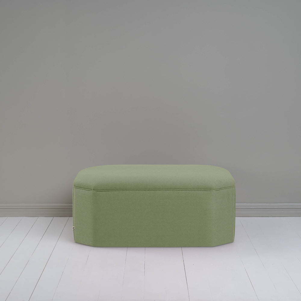 A small green ottoman, perfect for adding a touch of color and comfort to any room.