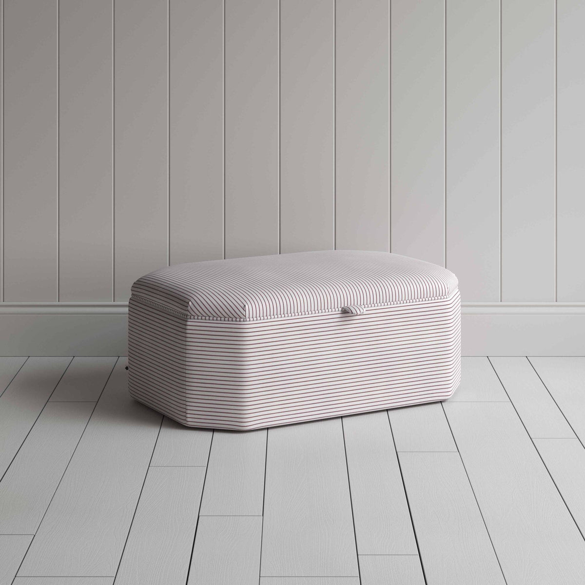 Stylish grey ottoman against white flooring.