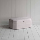 Stylish grey ottoman against white flooring.