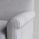 Close-up of the gracefully curved armrest on the Idler love seat in ticking cotton by Nix.