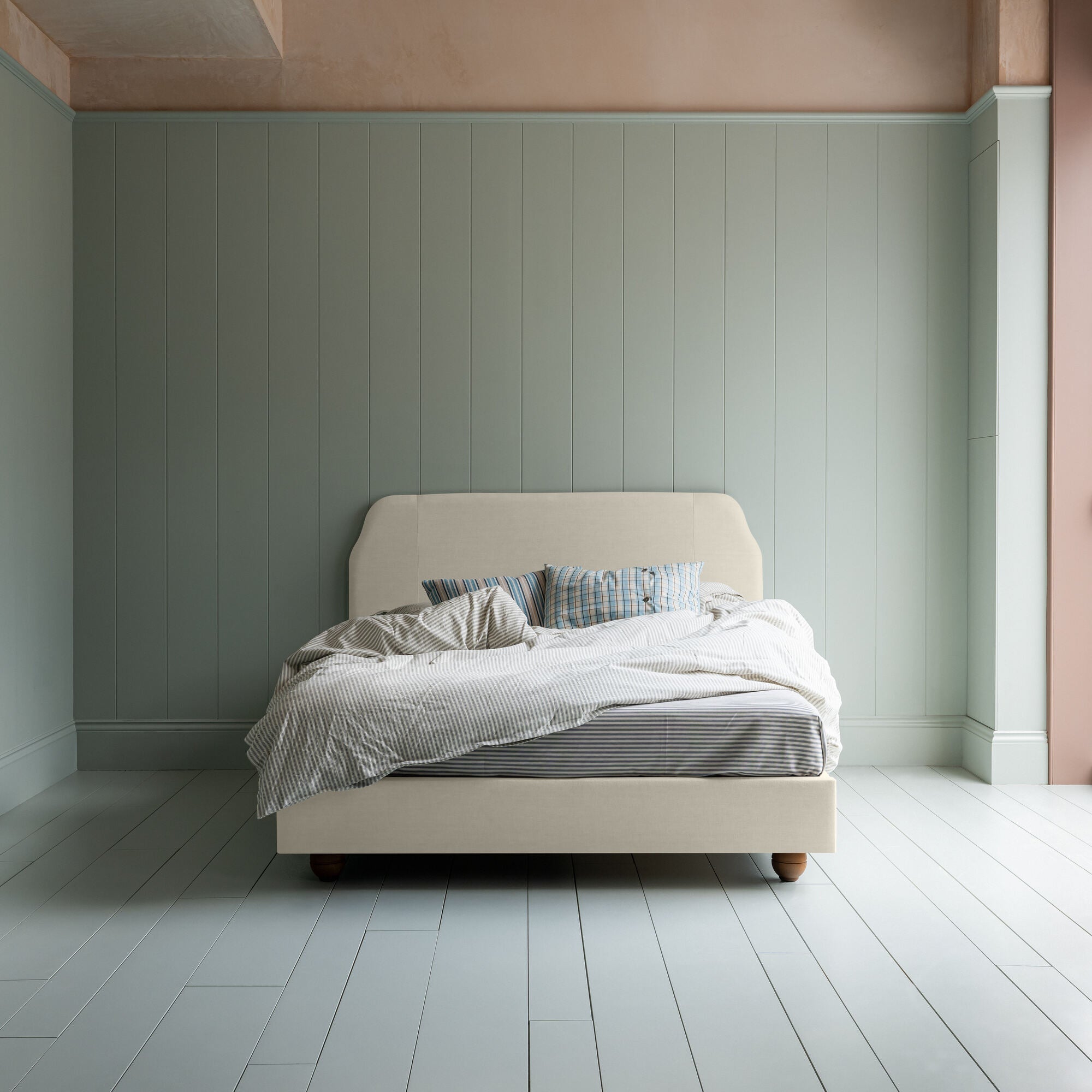  Dream Ticket upholstered bed in laidback linen dove without a valance, shown in a front view with blankets and pillows. 