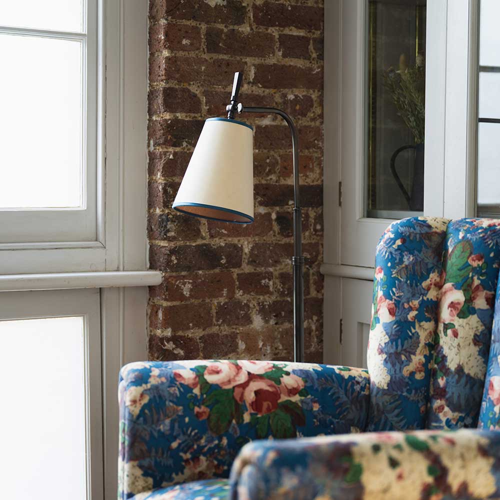  Brass Waxed Floor Lamp with To The Point Paper Empire Lamp Shade in Soft White with Peacock Blue Trim, Next to a Beautiful Armchair near a Window - NiX By Nicola Harding & Co. 