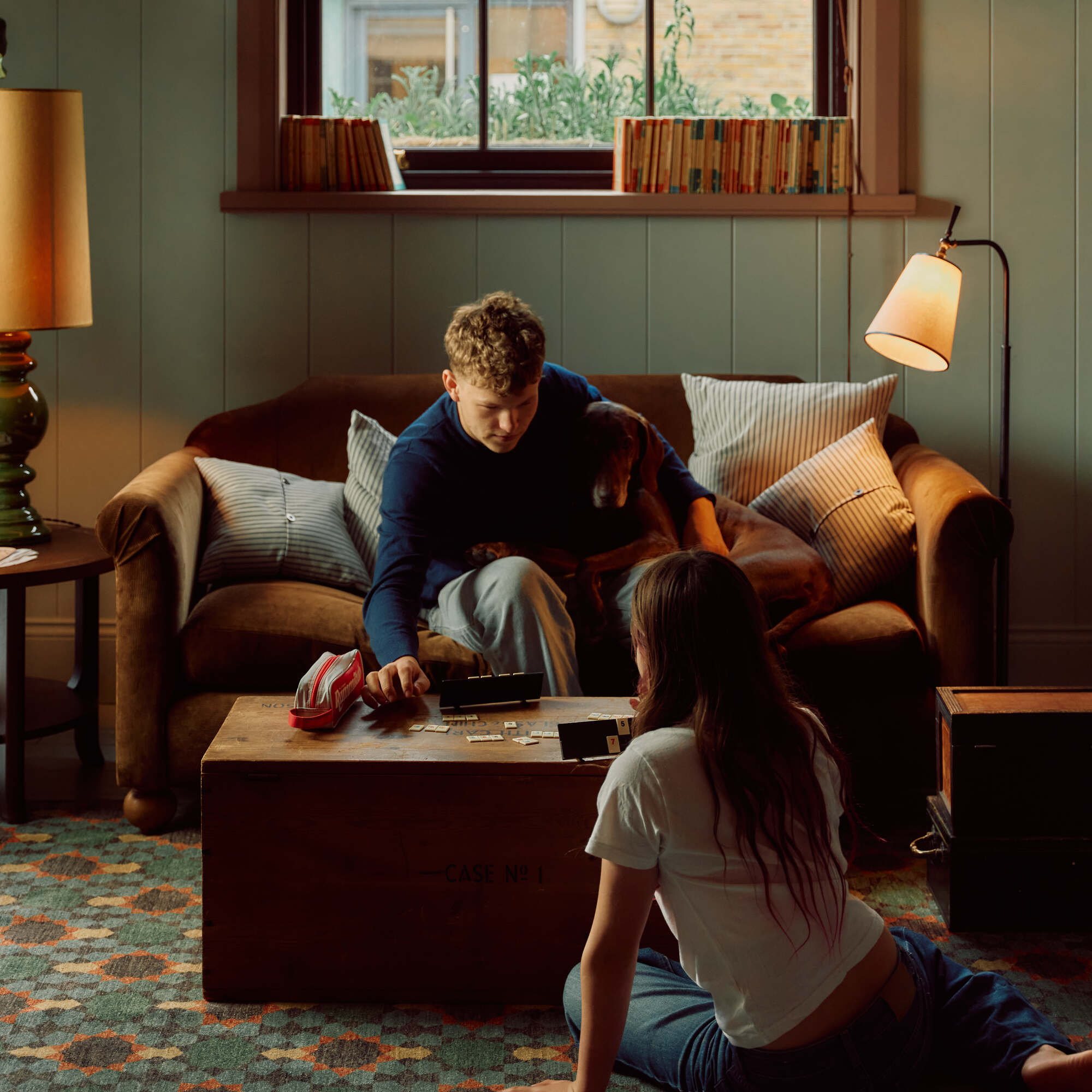  Dolittle sofa featured in a cozy lounge setup with patterned cushions and a floor lamp 