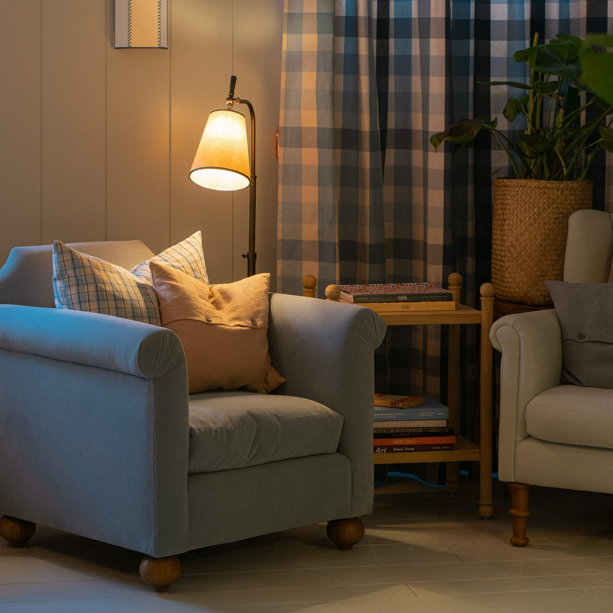  Nicola Harding interiors Dolittle armchair styled with a floor lamp and a wooden bobbin side table 