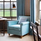 Idler armchair styled in a room with checkered cushion and a floor lamp - NiX