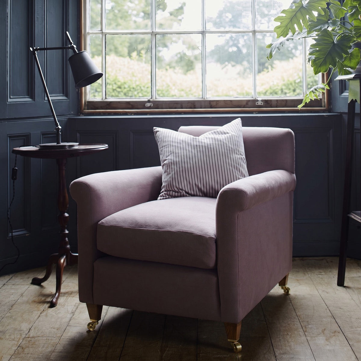 Idler Armchair styled beside a window with a cushion and a table lamp - Nicola Harding interior