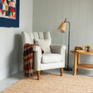 Time Out Armchair styled with a throw blanket and floor lamp in a cozy corner by Nicola Harding.