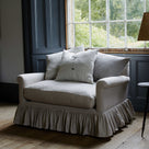 Curtain Call Love Seat positioned by a large window with natural light in a dark paneled room, styled layout by Nicola Harding interiors