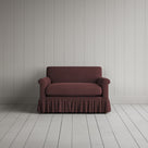 Curtain Call Love Seat playful skirted design in laidback linen damson, front studio view.