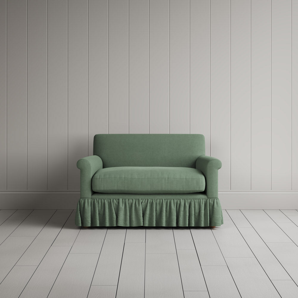  Curtain Call Love Seat playful skirted design in laidback linen moss, front studio view. 