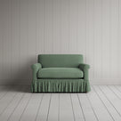 Curtain Call Love Seat playful skirted design in laidback linen moss, front studio view.
