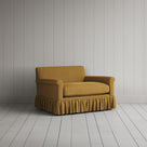 Nicola Harding interiors compact upholstered linen love seat with ruffled skirt base, angled studio view.