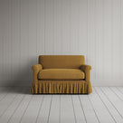 Curtain Call Love Seat playful skirted design in laidback linen ochre, front studio view.