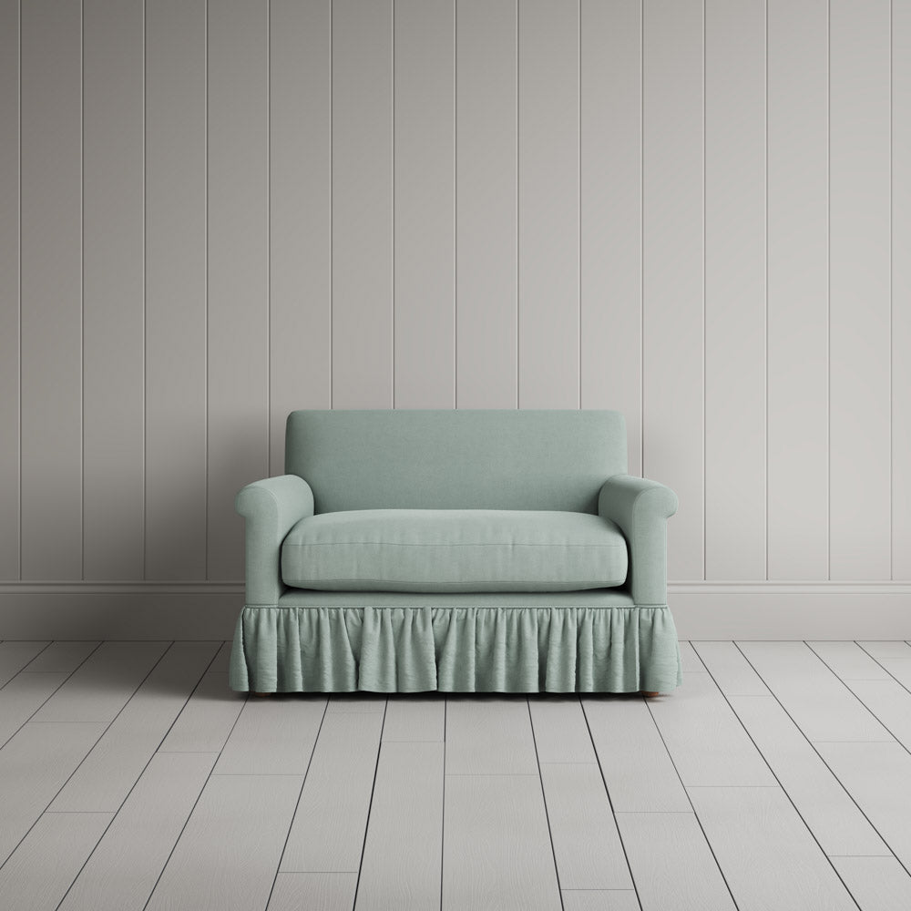  Curtain Call Love Seat playful skirted design in laidback linen sky, front studio view. 