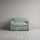 Curtain Call Love Seat playful skirted design in laidback linen sky, front studio view.