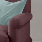 Detail of the armrest on the Damson Curtain Call sofa by NiX styled with a contrasting cushion.
