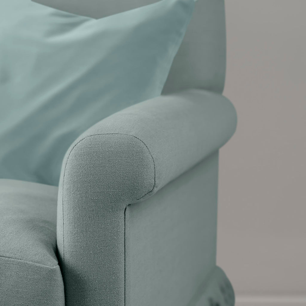  Close-up of premium linen upholstery on a Nicola Harding love seat with a decorative accent cushion. 
