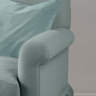 Close-up of premium linen upholstery on a Nicola Harding love seat with a decorative accent cushion.