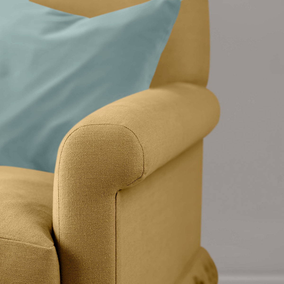 Close-up of premium linen upholstery on a Nicola Harding love seat with a decorative accent cushion.