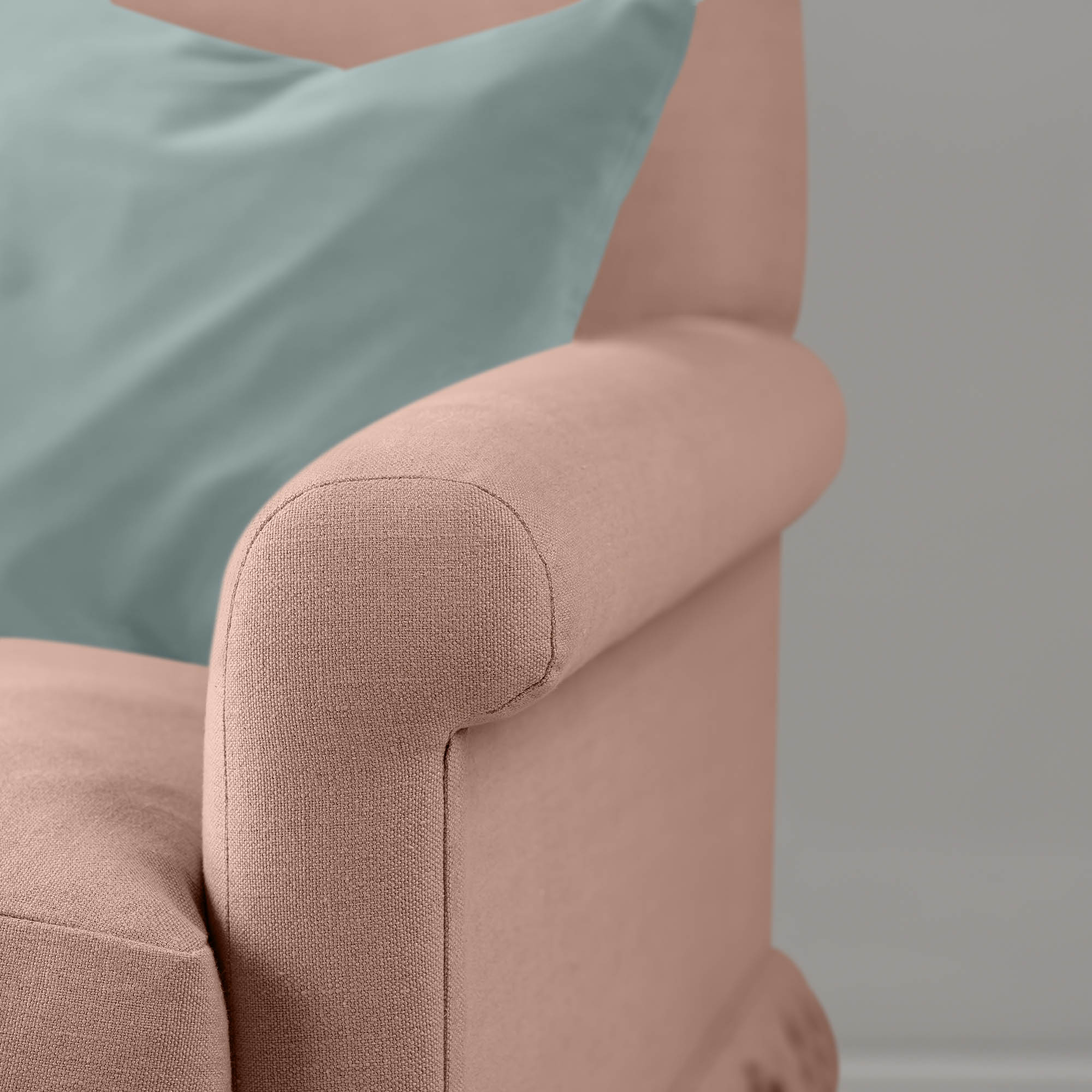  Detail of the scroll armrest on the Roseberry Curtain Call sofa by NiX styled with a contrasting green cushion. 
