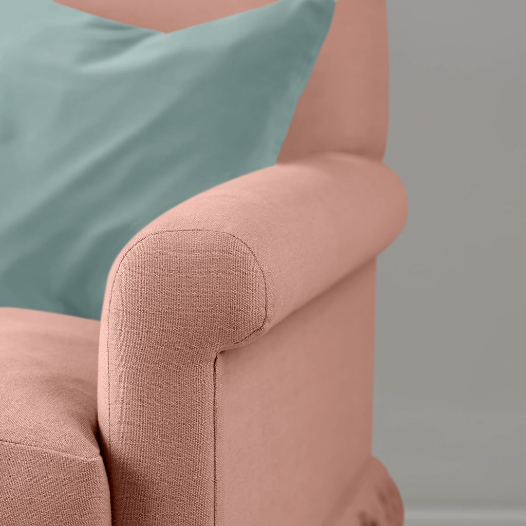  Detail of the scroll armrest on the Roseberry Curtain Call sofa by NiX styled with a contrasting green cushion. 