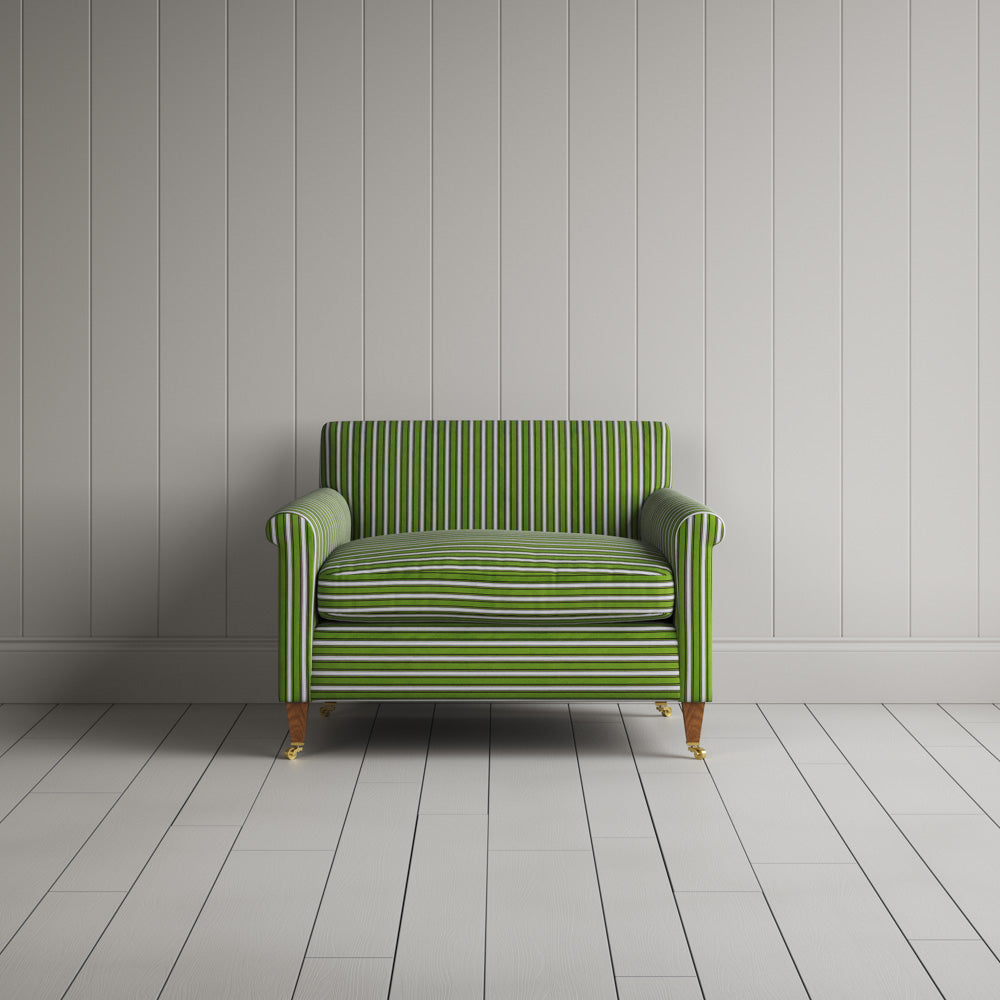 A green and white striped couch against a wall.