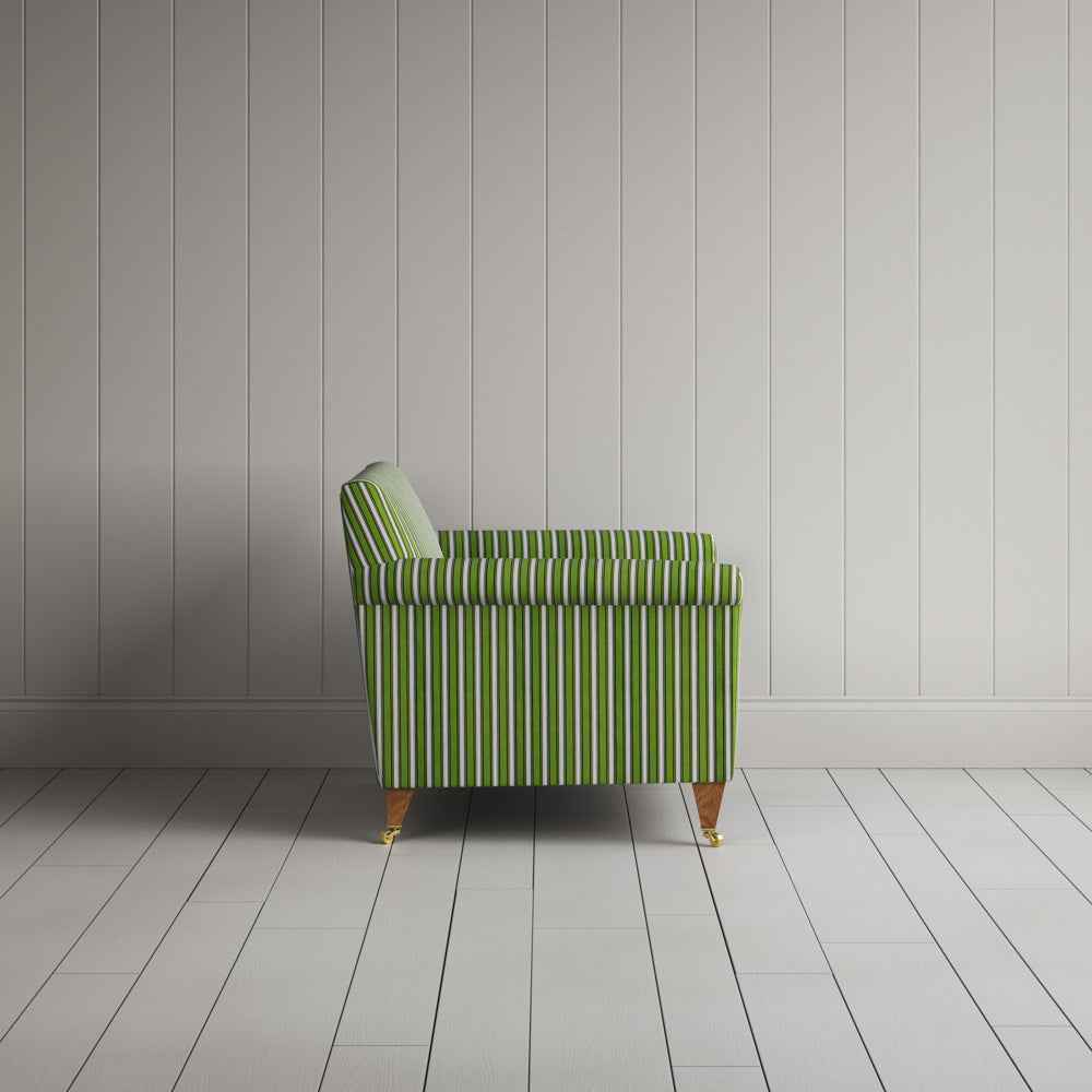  Striped green and white couch by a wall. 